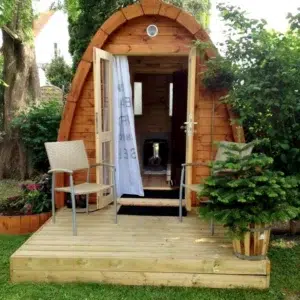 Outdoor pod sauna, open entrance on a garden deck