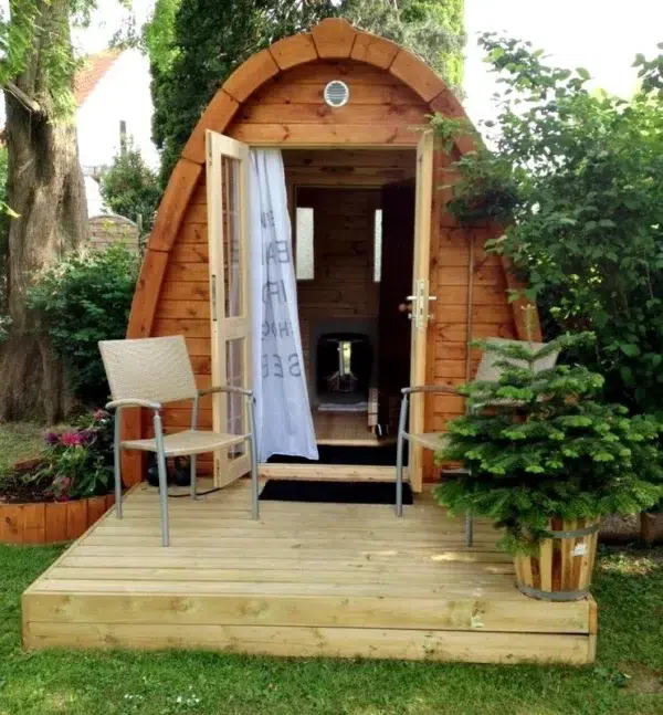 Outdoor pod sauna, open entrance on a garden deck