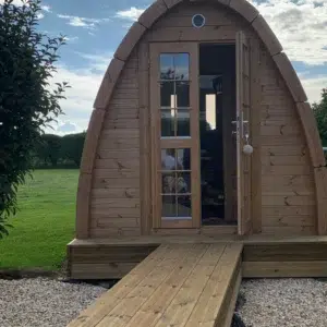 Outdoor pod sauna, open front door and wooden access ramp