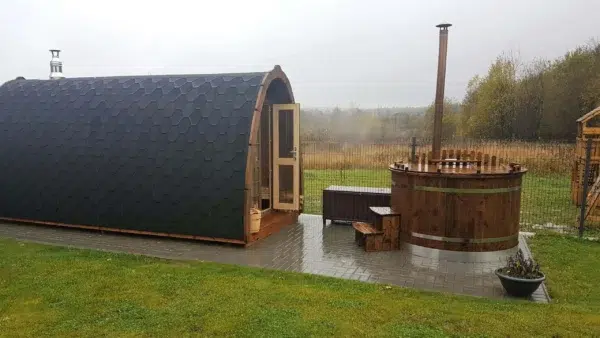 Outdoor pod sauna, side exterior beside an outdoor hot tub