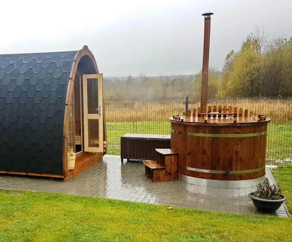 Outdoor pod sauna, side exterior beside a wood-fired hot tub