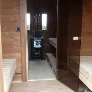 Outdoor pod sauna, view through changing area to the sauna stove