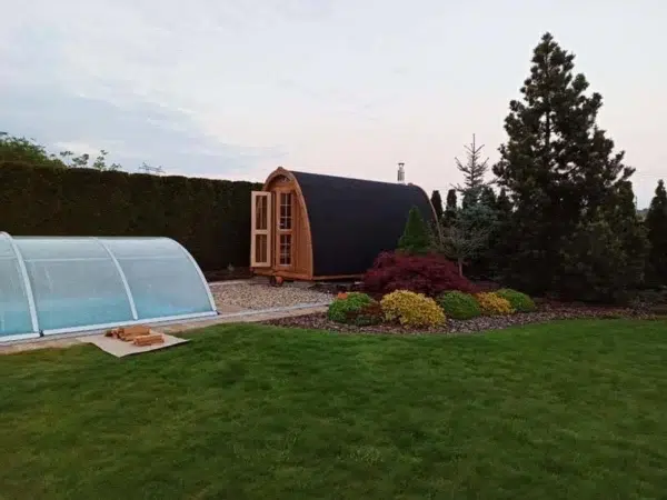 Outdoor pod sauna, wide garden installation beside a pool