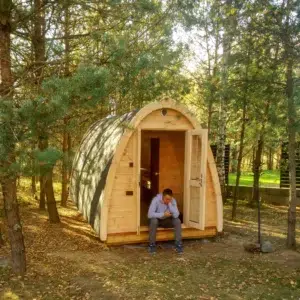 Outdoor pod sauna, woodland installation with a person at the entrance