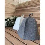 TESLI grey natural felt sauna hat, grey and white hats on a wooden sauna bench