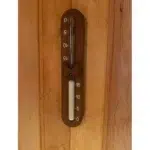 TESLI sand timer with Thermowood Frame, timer mounted on a wooden sauna wall