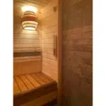 TESLI SYDNEY Sauna Light Cover, illuminated above a sauna bench