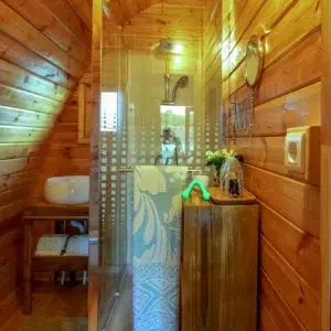 Wooden camping pod, bathroom area with shower and washbasin