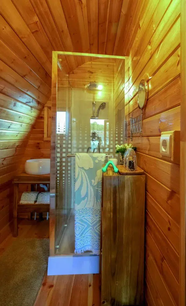 Wooden camping pod, bathroom area with shower and washbasin