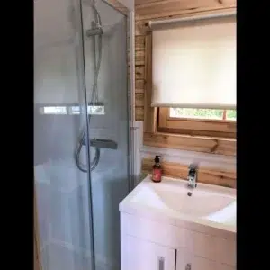 Wooden camping pod, bathroom with shower and washbasin