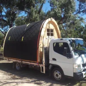 Wooden camping pod, camping pod transported on a flatbed truck
