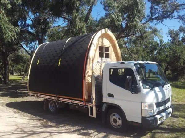 Wooden camping pod, camping pod transported on a flatbed truck