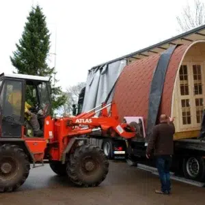 Wooden camping pod, camping pod unloaded from a truck with a forklift