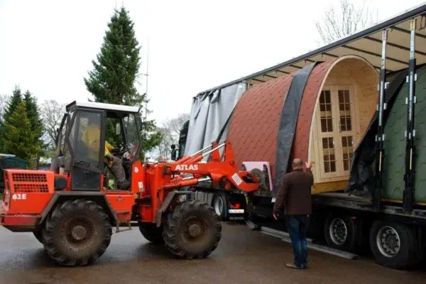 Wooden camping pod, camping pod unloaded from a truck with a forklift