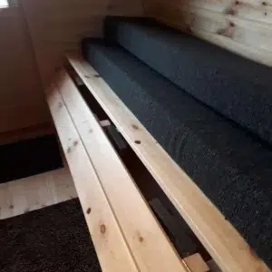 Wooden camping pod, close-up of convertible bench platform