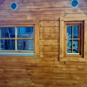 Wooden camping pod, close view of rear windows and round vents