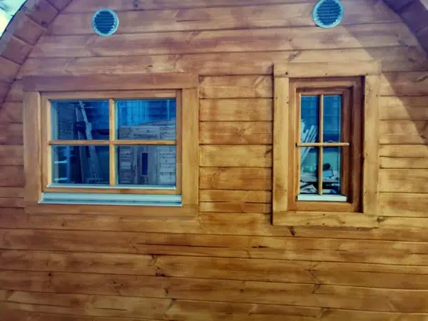 Wooden camping pod, close view of rear windows and round vents
