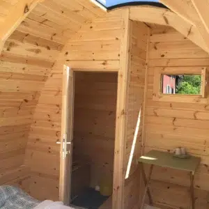 Wooden camping pod, curved interior ceiling and washbasin area
