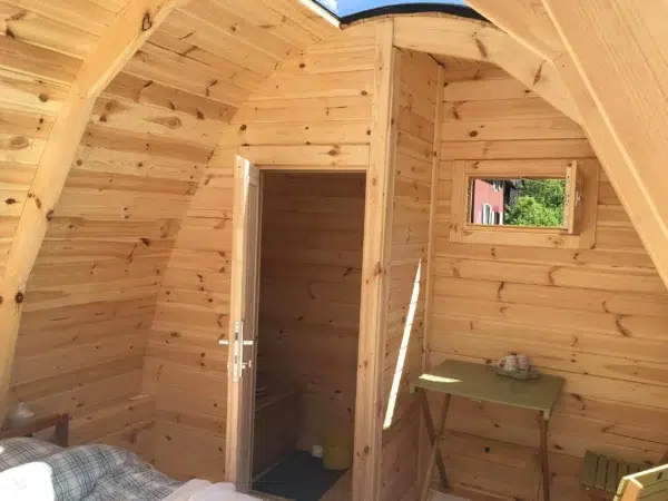 Wooden camping pod, curved interior ceiling and washbasin area