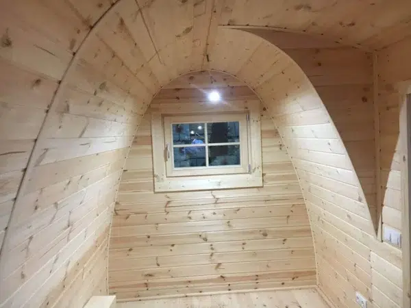 Wooden camping pod, curved interior wall and small window