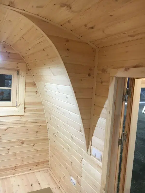 Wooden camping pod, curved wooden interior partition and doorway