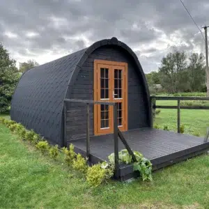 Wooden camping pod, dark exterior with front deck