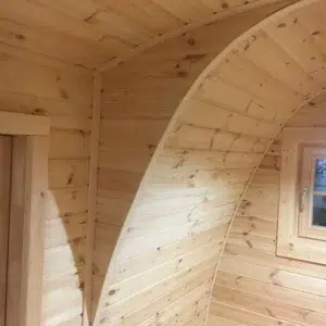 Wooden camping pod, detail of curved wooden interior partition