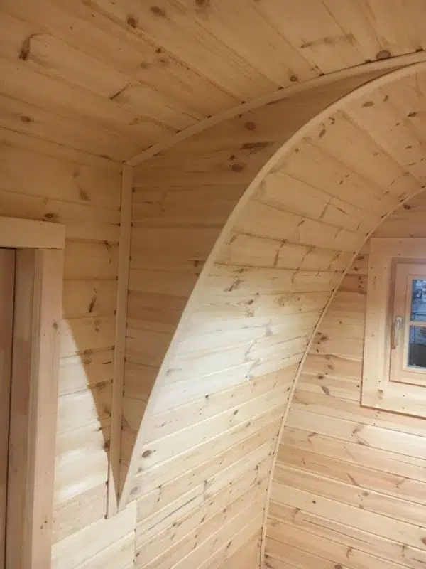 Wooden camping pod, detail of curved wooden interior partition