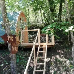 Wooden camping pod, elevated woodland installation with steps and deck