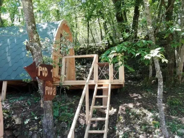 Wooden camping pod, elevated woodland installation with steps and deck