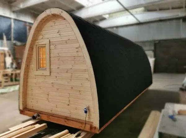 Wooden camping pod, end wall and side roof in a workshop