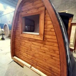 Wooden camping pod, end wall and window in a workshop