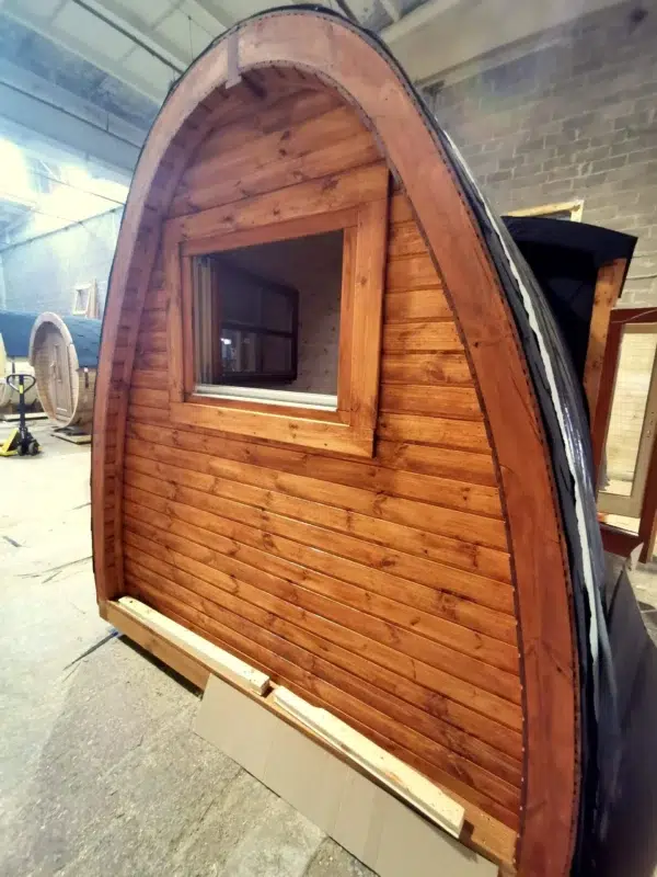 Wooden camping pod, end wall and window in a workshop