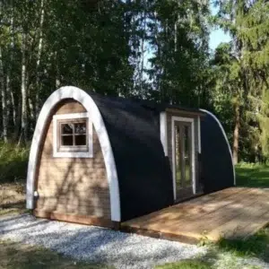 Wooden camping pod, exterior beside a wooden deck among trees