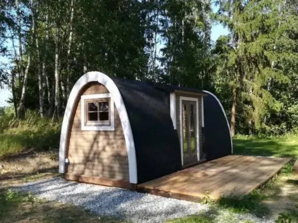 Wooden camping pod, exterior beside a wooden deck among trees