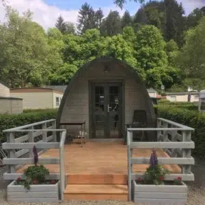Wooden camping pod, front entrance with raised deck and railings
