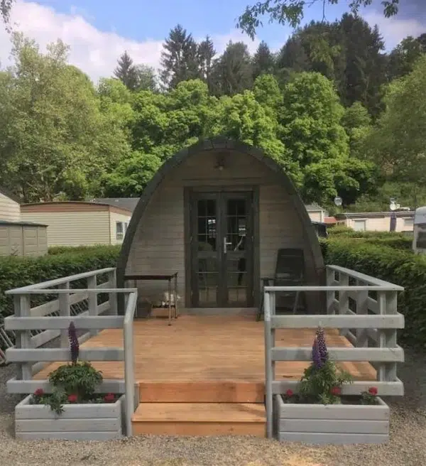 Wooden camping pod, front entrance with raised deck and railings