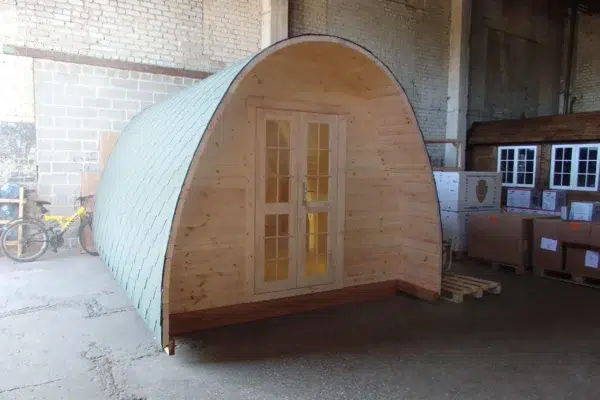 Wooden camping pod, front exterior with arched roof and double doors