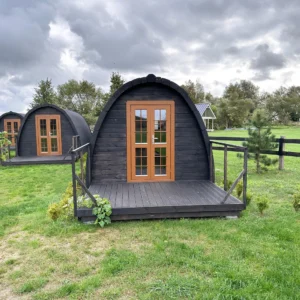 Wooden camping pod, front exterior with deck railings