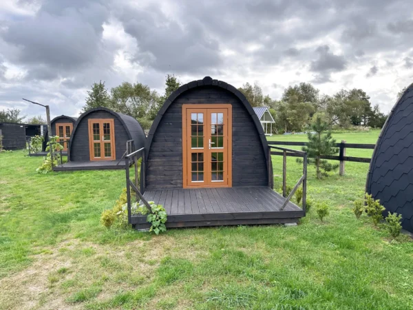 Wooden camping pod, front exterior with deck railings