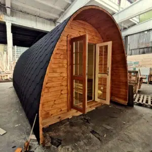 Wooden camping pod, front exterior with open glazed doors