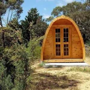 Wooden camping pod, front exterior in a wooded setting