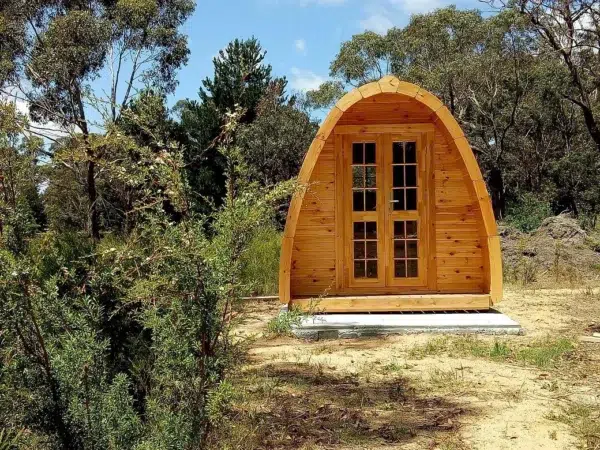 Wooden camping pod, front exterior in a wooded setting