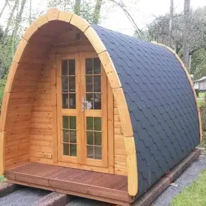 Wooden camping pod, front and side exterior with dark shingle roof