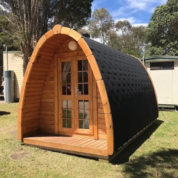 Wooden camping pod, front and side exterior on grass