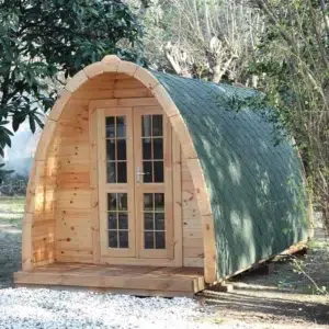 Wooden camping pod, front and side exterior with green roof