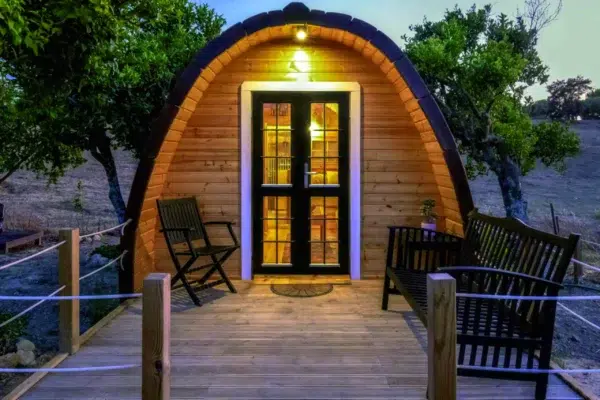 Wooden camping pod, illuminated entrance and furnished deck