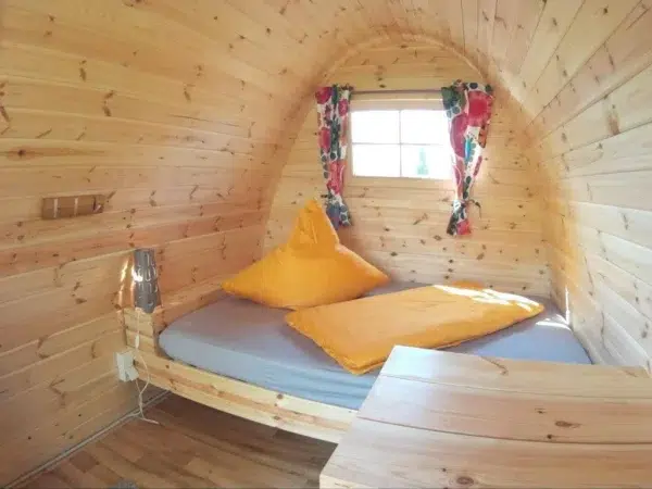 Wooden camping pod, interior bed and small wooden table