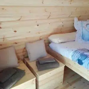 Wooden camping pod, interior bed and two seats