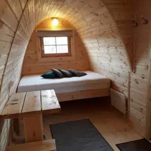 Wooden camping pod, interior bed and wooden table